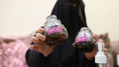 Umm Hamad holding one of her popular perfumes, Saif, which is named after her late husband. Fatima Al Marzooqi / The National