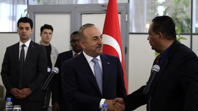 Sudanese Foreign Minister Ibrahim Ghandour shakes hands with his Turkish counterpart Mevlut Cavusoglu during a press conference at Khartoum International Airport. Ebrahim Hamid / AFP