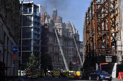 Firefighters tackle a blaze at the Mandarin Oriental hotel in central London on June 6, 2018. A fire broke out at London's Mandarin Oriental hotel, with dozens of firefighters deployed to tackle the blaze that pumped smoke high into the air over the British capital. / AFP / Ben STANSALL