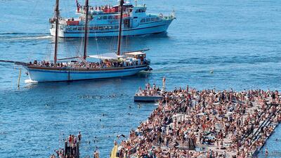 Boats sail past the crowded bathing area at Sorenga in Oslo at the Norwegian capital's inner harbor pool. Weather forecasters predict new temperature highs across western Europe hit by another heatwave setting new temperature records. AFP