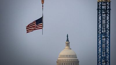An American flag on a construction crane in front of the US Capitol in Washington. Bloomberg