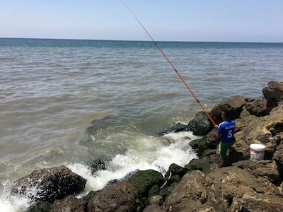A resident of the southern Beirut neighbourhood of Ouzai fishes meters from where raw sewage enters the Mediterranean, turning the water grey. Residents say the problem has existed for years. June 28, 2018. David Enders for The National