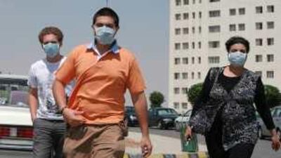 People in Amman wear masks to protect themselves against swine flu, which the authorities fear will be spread by kissing over Eid.