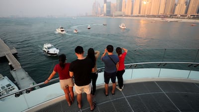 Tourists take in the views at Jumeirah Beach Residence in Dubai. Chris Whiteoak / The National