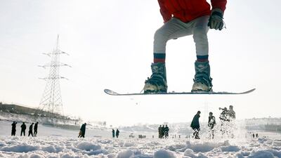 An Afghan snowboard federation member preforms during a practice session on a snow-covered hilltop in Kabul. EPA