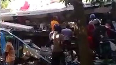 A handout picture made available by Jean David Geneste shows people next to rubble after the earthquake.