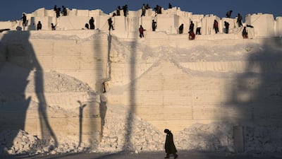 A team of Chinese labourers carve into a large snow mound in preparation for the Harbin Ice and Snow Festival in Harbin, China. Getty Images