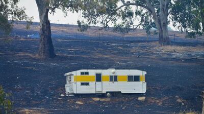 A caravan saved from the fire sits on charred earth near One Tree Hill in the Adelaide Hills, northeast of Adelaide, on January 3, 2015. Brenton Edwards/AFP Photo