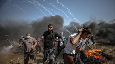 Palestinian protesters run for cover from Israeli tear-gas during the clashes after Friday protest near the border east Gaza City on, 08 June 2018. Protesters called for the right of Palestinian refugees across the Middle East to return to homes they fled in the war surrounding the 1948 creation of Israel. Mohammed Saber / EPA