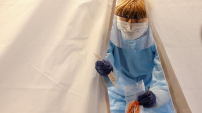 A nurse walks out of a tent with a test kit at a drive-through testing for coronavirus in Seattle, Washington. Reuters