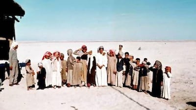 Two dozen eager children gather on the sands of Abu Dhabi for Deborah Hillyard’s fourth birthday party in 1957. The thin shadow at centre right could be from a pole atop the Hillyards’ home. Courtesy Literary Estate of Roderic Owen