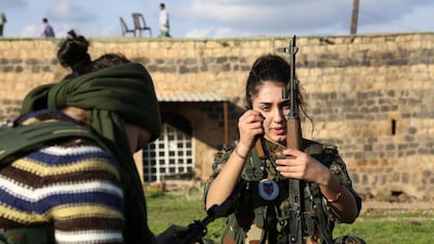 Syriac Christian Ormia, member of the battalion called the “Female Protection Forces of the Land Between the Two Rivers” fighting the Islamic State group, loads her weapon during a training at their camp in the town of Al Qahtaniyah, near the Syrian-Turkish border. Delil Souleiman / AFP Photo