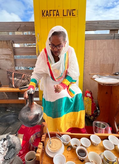 Emebyt Demke, 51, sets down a jebena, or Ethiopian clay coffee pot, after pouring coffee into a small, traditional coffee cup, also known as a sini, at Kaffa Coffee in East London. AP Photo