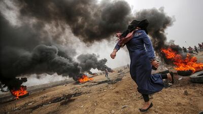A female Palestinian protester throws stones during clashes after Friday protests near the border with Israel in eastern Gaza City. Mohammed Saber / EPA