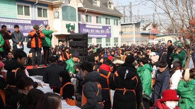 Workers and volunteers give out free lunch boxes and other warm goods to citizens in Dongdaemun market in western Seoul, South Korea. EPA