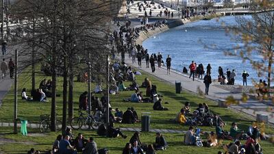 People walk along the bank of the Rhone river in Lyon. AFP