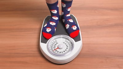 Close up of woman's feet standing on scales on wooden floor