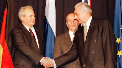 Alija Izetbegovic, president of the Republic of Bosnia-Herzegovina (C), looks on as Franjo Tudjman (R), president of the Republic of Croatia, and Slobodan Milosevic (L), president of the Republic of Serbia shake hands after initializing a peace accord 21 November, 1995. AFP