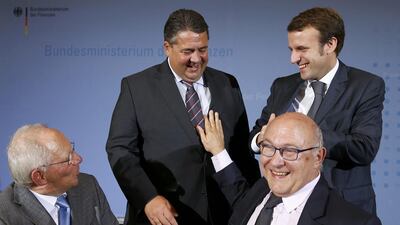 German economy and finance ministers Sigmar Gabriel and Wolfgang Schaeuble (left) and their French counterparts Michel Sapin (second right) and Emmanuel Macron (right) smile after a news conference at the finance ministry in Berlin on October 20, 2014. Germany and France agreed on Monday to work towards a deal to boost investment and accelerate economic reforms to revive a stagnating euro zone economy, their finance ministers said. Thomas Peter / Reuters