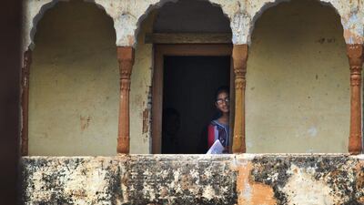 A girl looks out from the doorway of her classroom in Sorkhi.