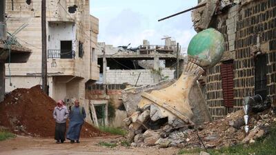 Elderly men walk past a damaged mosque in a rebel-held area of Daraa, in southern Syria. Mohamad Abazeed / AFP