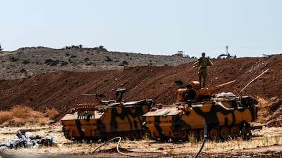 A Turkish soldier stands on an army armoured vehicle on October 8, 2017 at Syria-Turkey border at Reyhanli district in Hatay. Ilyas Akengin / AFP