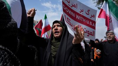 An Iranian holds up an anti-US placard during a protest after the Friday prayers in Tehran. AP
