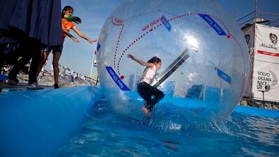 Children play in an inflatable ball at Volvo's Destination Village. Boats finished the second leg, Cape Town to Abu iDhabi, of the Volvo Ocean Race on Wednesday, Jan. 4, 2012, at the Breakwater Corniche in Abu Dhab. (Silvia Razgova/The National)