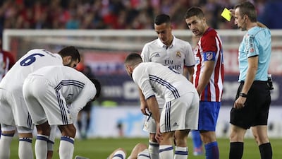 Spanish referee Fernandez Borbalan, right, shows a yellow card to Atletico Madrid’s Gabi. Chema Moya / EPA