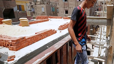 A youth stands in front of a housing construction site next to his home in Al Assal. Amr Abdallah Dalsh/Reuters