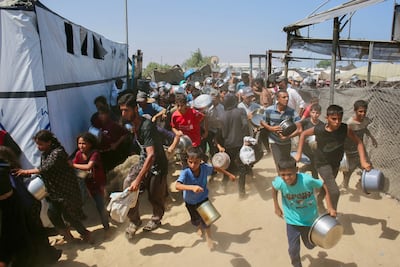 Children collect food from a charity kitchen in Gaza, where the economy has collapsed due to the war. AFP