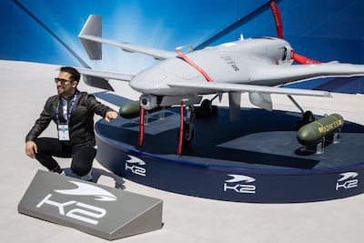A man poses for a photograph in front of the Baykar K2 drone on display at the Saha expo. Getty Images