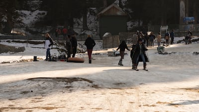 Tourists venture out to ski and sledge on a thin layer of snow. Wasim Nabi for The National