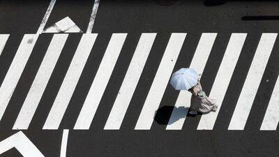 A woman protects herself from the sun with a parasol in Tokyo. Chris Whiteoak / The National