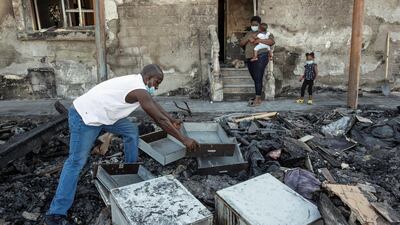 The Akinmoladun family sift through the ruins of their furniture store. Antonie Robertson / The National