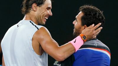 Rafael Nadal, left, and Victor Estrella Burgos of Dominican Republic embrace after the former won their Australian Open first-round match. Thomas Peter / Reuters