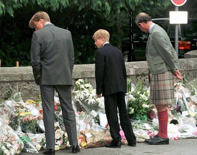 Prince William, Prince Harry and Prince Charles stop to look at floral tributes left for Princess Diana at the gates of Balmoral Castle, Scotland, on September 4, 1997. AFP