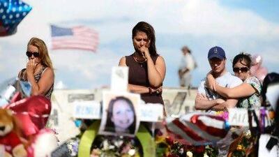 Cynthia Davis (centre) gets emotional as she visits a roadside memorial set up for victims opposite the Century 16 cinema where the shooting took place.