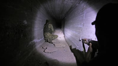 Turkish-backed Syrian fighters inspect a tunnel, said to have been built by Kurdish fighters, in the Syrian border town of Tal Abyad. TAFP