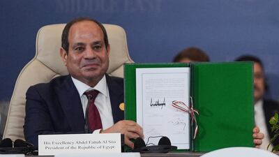 Egypt's President Abdel Fattah El Sisi holds up the declaration signed by himself and the leaders of the US, Qatar and Turkey. AP