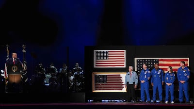 Retired astronaut Harrison Schmitt, Artemis II crew members Reid Wiseman, Victor Glover, Christina Koch and Jeremy Hansen stand on stage as Mr Trump speaks. AFP