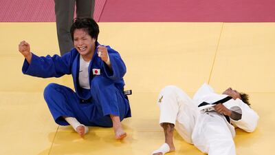Japan's Uta Abe, of Japan, left, celebrates after defeating Amandine Buchard, of France in the women's -52kg gold medal judo match.