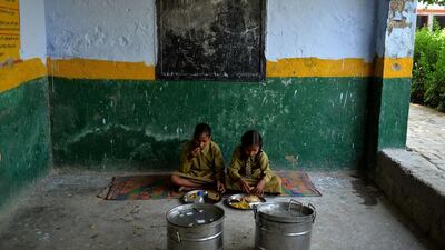 Indian schoolgirls eat lunch together at the Chaumuha Primary School.