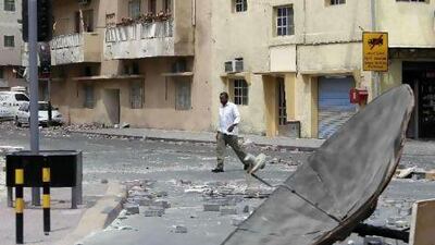 A man walks past makeshift barricades placed by anti-government demonstrators at a Shiite neighbourhood in Manama yesterday.