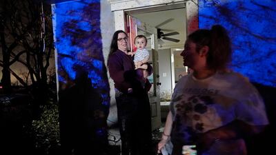Annelise Cassar holds her nephew Eliam Cruice, 9 months, amid damage from the tornado. AP Photo