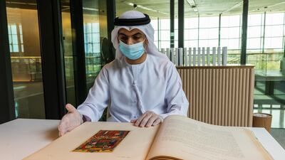 A staff member from Sharjah's House of Wisdom with one of the books donated by the emirate's Ruler