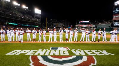 Members of the Washington Nationals wave as they stand on the first base line during pregame festivities in the opening day baseball game against the New York Mets at Nationals Park in Washington. AP
