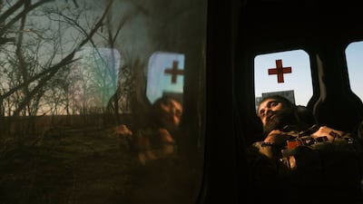 A Ukrainian serviceman rests while travelling with a team of humanitarian volunteers in the Kherson area in 2022. EPA