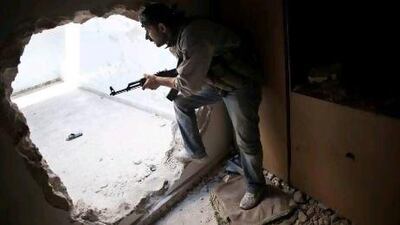 A Free Syrian Army fighter takes position during clashes with government forces in the Karmal Jabl district of Aleppo. Human Rights Watch claims to have evidence the Assad regime is now using cluster bombs