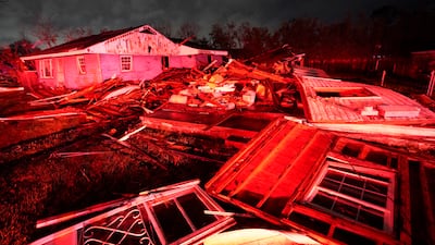 Destroyed homes lit up by fire engine lights. AP Photo